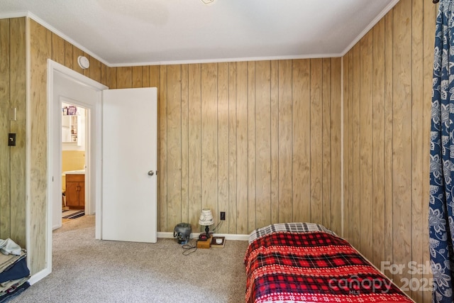carpeted bedroom featuring crown molding and wooden walls