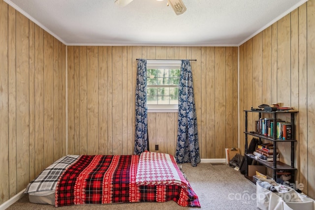 carpeted bedroom with wooden walls, a ceiling fan, and a textured ceiling