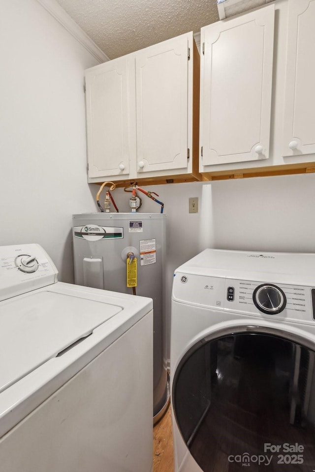 washroom with washing machine and dryer, light wood-type flooring, cabinet space, ornamental molding, and electric water heater