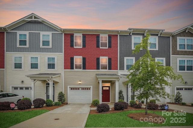townhome / multi-family property with an attached garage and driveway