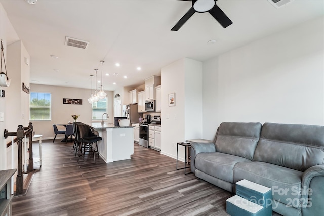 living room featuring recessed lighting, visible vents, a ceiling fan, and dark wood-style floors