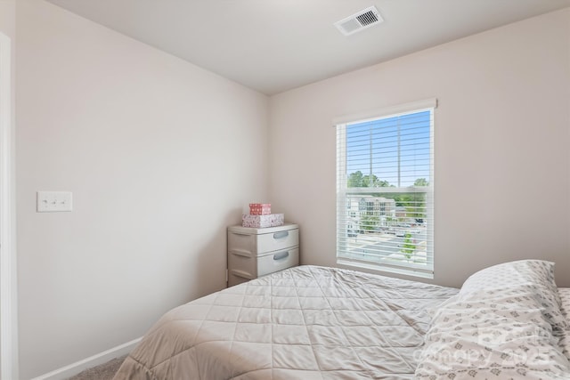 bedroom with baseboards, visible vents, and carpet floors