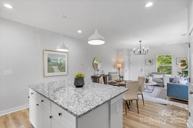 1914 White St Unit A & B, Gastonia, NC 28052 - kitchen with light stone countertops, light wood-style flooring, a center island, white cabinetry, and open floor plan