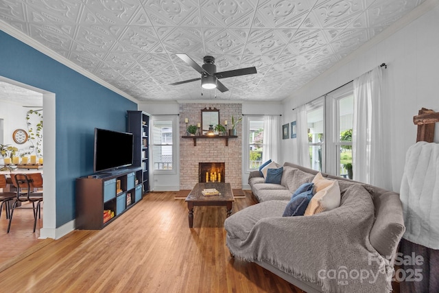 1001 Old Charlotte Rd, Concord, NC 28027 - living room with a brick fireplace, ceiling fan, light wood finished floors, an ornate ceiling, and baseboards