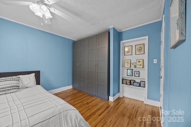 1001 Old Charlotte Rd, Concord, NC 28027 - bedroom featuring baseboards, wood finished floors, ornamental molding, a textured ceiling, and ceiling fan