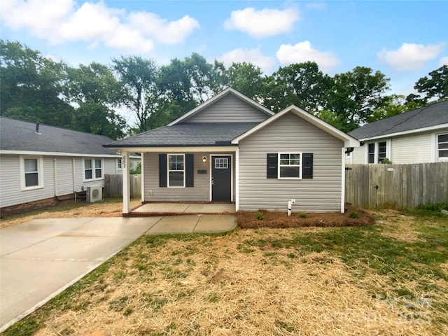 view of front of home with a porch, fence, ac unit, and a front yard