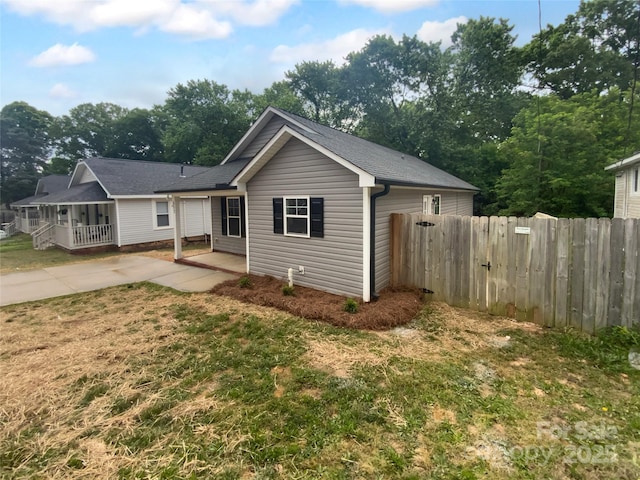 rear view of property with fence and a lawn
