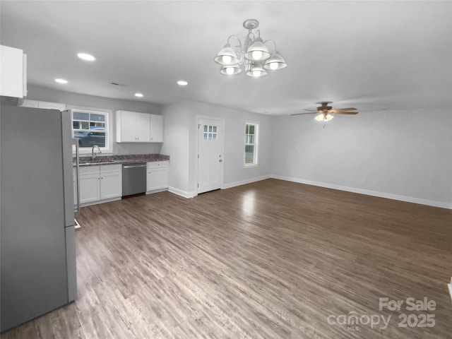 kitchen featuring a sink, appliances with stainless steel finishes, ceiling fan with notable chandelier, and a wealth of natural light
