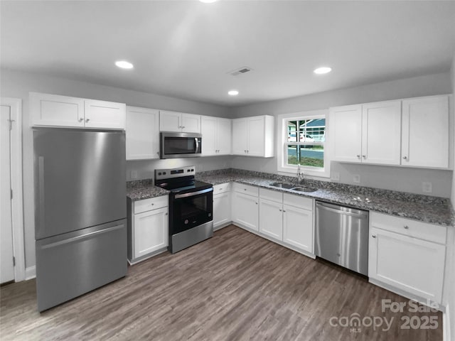 kitchen with recessed lighting, a sink, white cabinetry, and appliances with stainless steel finishes