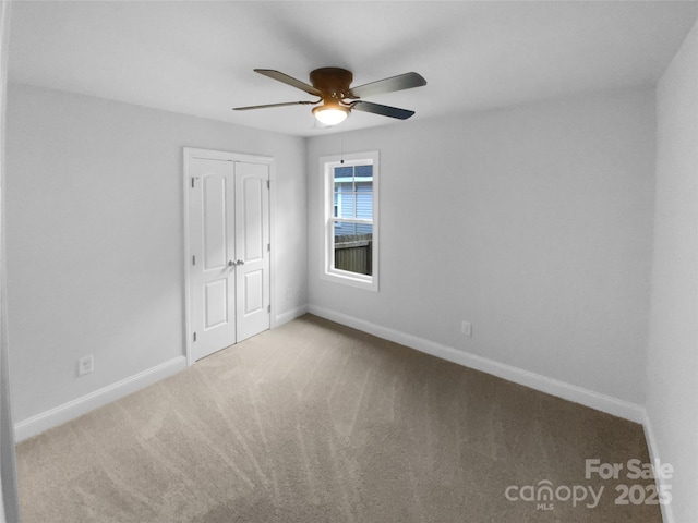 empty room with baseboards, a ceiling fan, and carpet flooring
