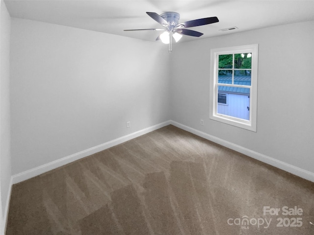 spare room with carpet floors, a ceiling fan, baseboards, and visible vents