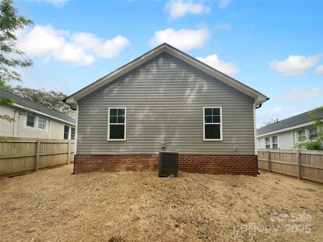 rear view of property with cooling unit and a fenced backyard