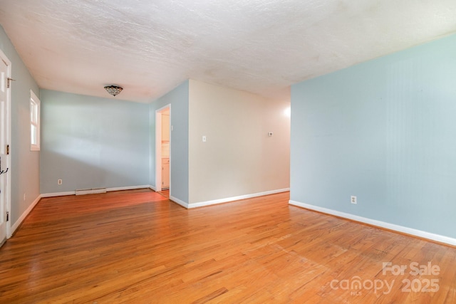 empty room featuring light wood-style floors, baseboards, and visible vents