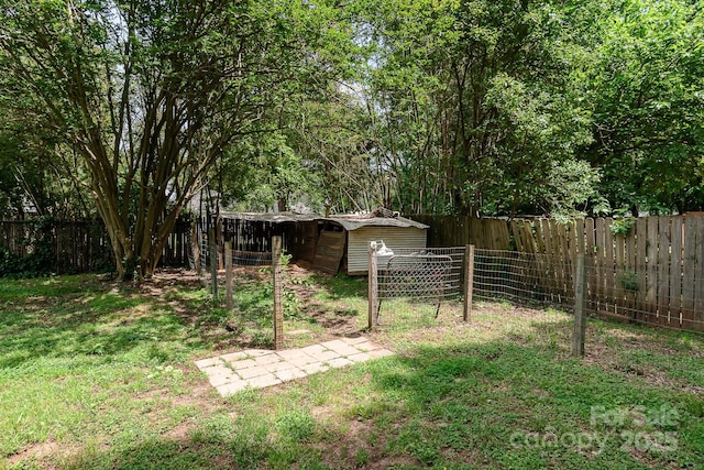 view of yard with an outdoor structure, a shed, and a fenced backyard