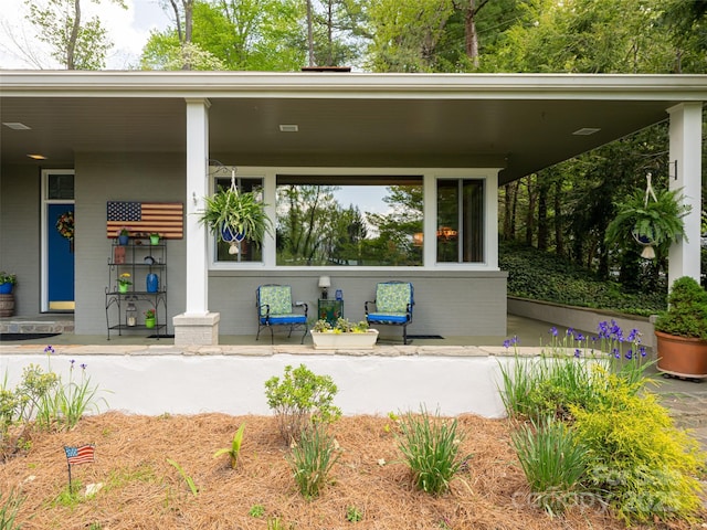 property entrance featuring brick siding and covered porch
