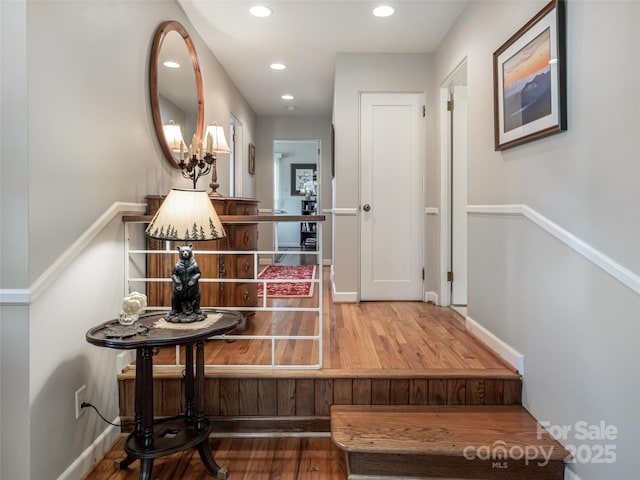 hallway featuring recessed lighting, baseboards, and wood finished floors