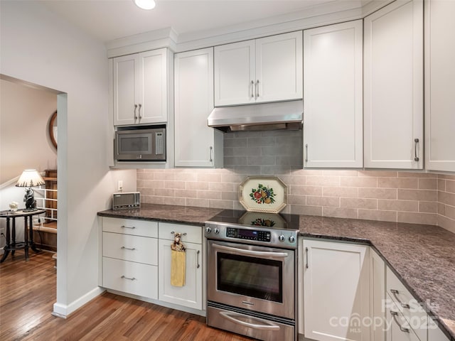 kitchen with backsplash, appliances with stainless steel finishes, light wood-style floors, under cabinet range hood, and white cabinetry