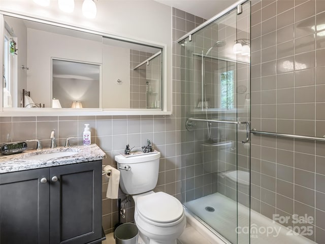 bathroom featuring tile walls, a stall shower, and toilet