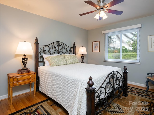 bedroom with baseboards, ceiling fan, and wood finished floors