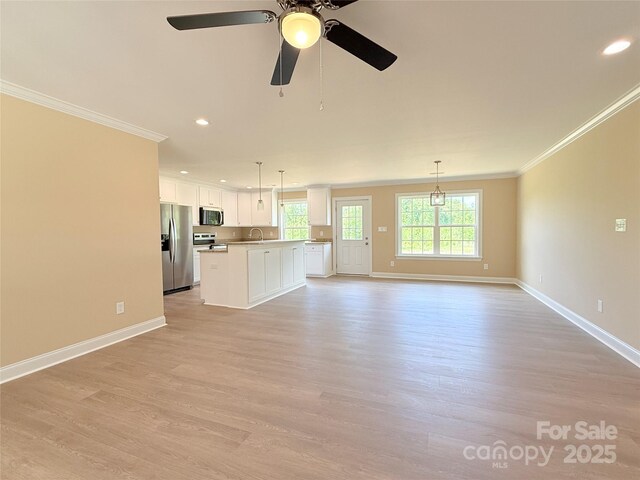 unfurnished living room with light wood finished floors, recessed lighting, baseboards, a ceiling fan, and ornamental molding