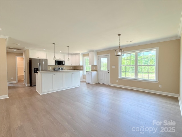 kitchen with light countertops, appliances with stainless steel finishes, ornamental molding, and baseboards