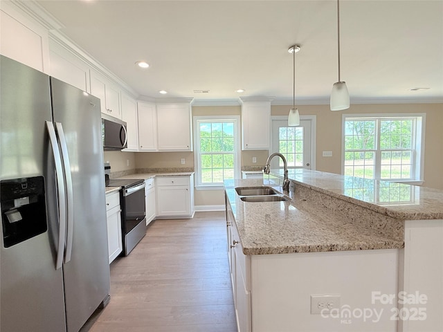 kitchen featuring a sink, light wood-style flooring, appliances with stainless steel finishes, and a healthy amount of sunlight