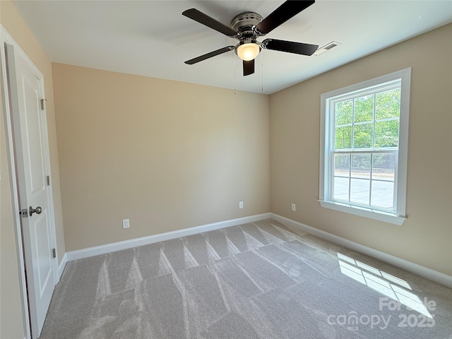 unfurnished room featuring baseboards, a ceiling fan, light colored carpet, and visible vents