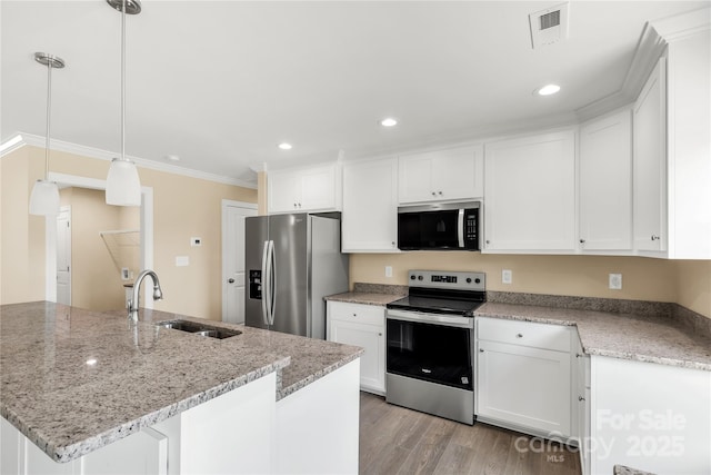 3650 Sentry Rd, Lancaster, SC 29720 - kitchen featuring appliances with stainless steel finishes, ornamental molding, white cabinets, light wood-type flooring, and light stone counters