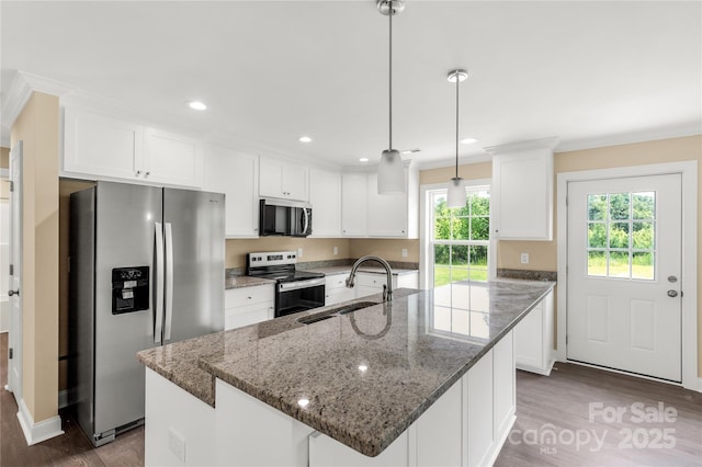 3650 Sentry Rd, Lancaster, SC 29720 - kitchen with stainless steel appliances, wood finished floors, white cabinets, ornamental molding, and an island with sink