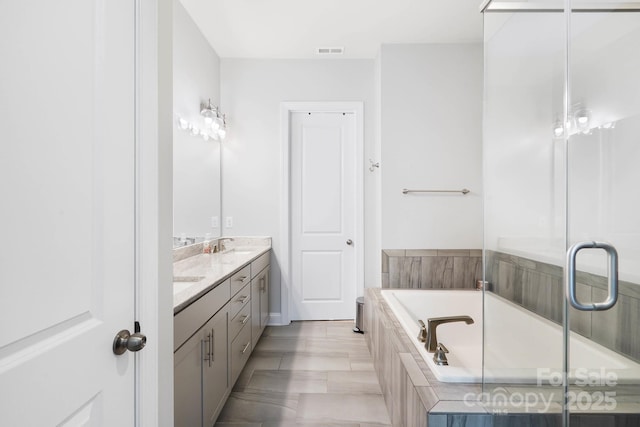 bathroom featuring a garden tub and double vanity