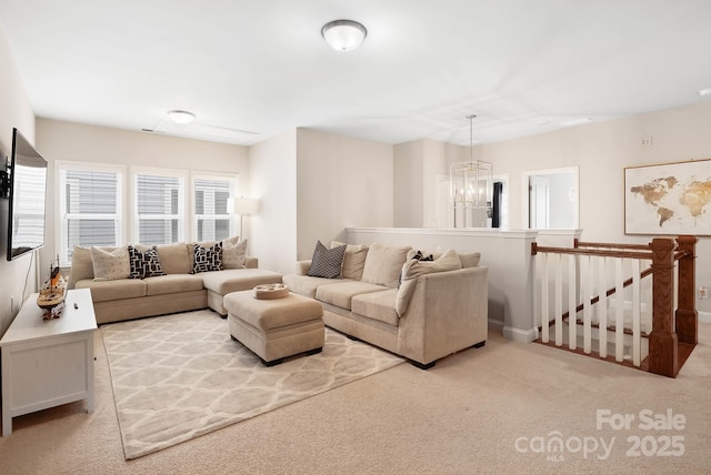 carpeted living area featuring a chandelier