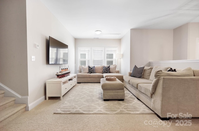living area featuring light carpet and baseboards