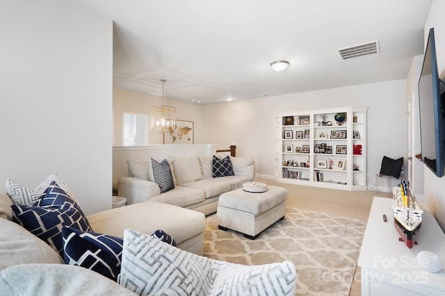 carpeted living area featuring a chandelier