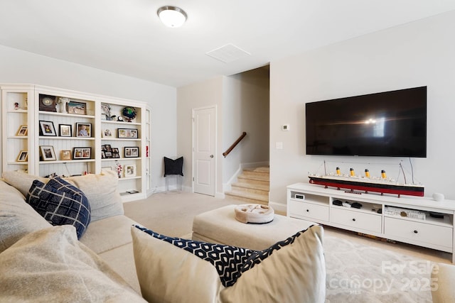 living area with stairway, light carpet, and baseboards