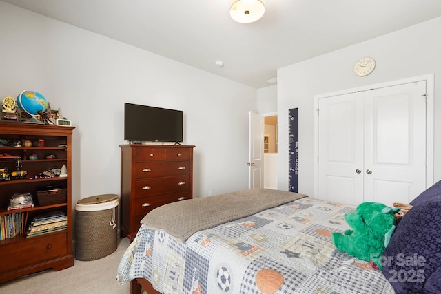 bedroom with light carpet and a closet