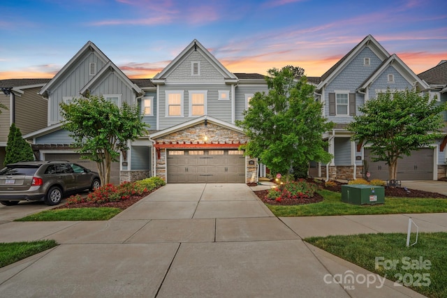 view of front of home featuring stone siding, driveway, an attached garage, and board and batten siding
