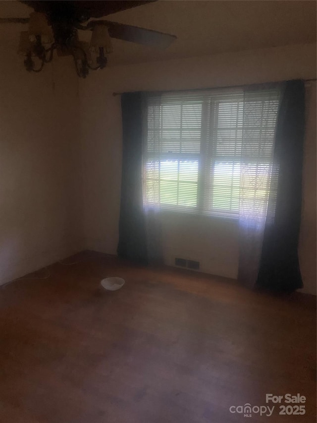spare room with wood finished floors and visible vents