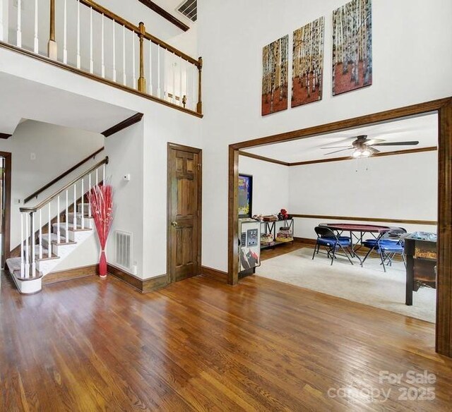 8524 Quarters Ln, Mint Hill, NC 28227 - entrance foyer with baseboards, ceiling fan, wood finished floors, a high ceiling, and stairway