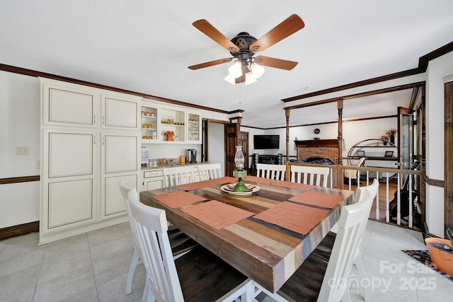 8524 Quarters Ln, Mint Hill, NC 28227 - dining room featuring a ceiling fan, crown molding, baseboards, a brick fireplace, and light tile patterned floors