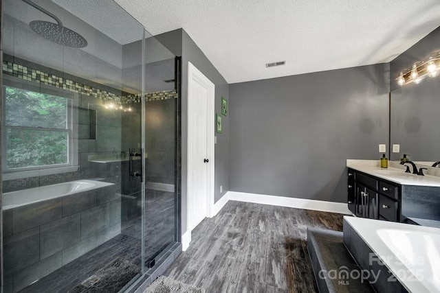8524 Quarters Ln, Mint Hill, NC 28227 - full bathroom featuring a garden tub, vanity, a stall shower, wood finished floors, and a textured ceiling
