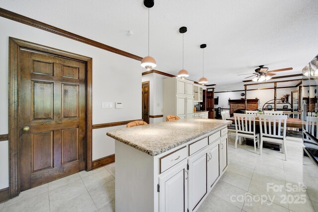 8524 Quarters Ln, Mint Hill, NC 28227 - kitchen featuring a ceiling fan, crown molding, white cabinets, light tile patterned floors, and a center island