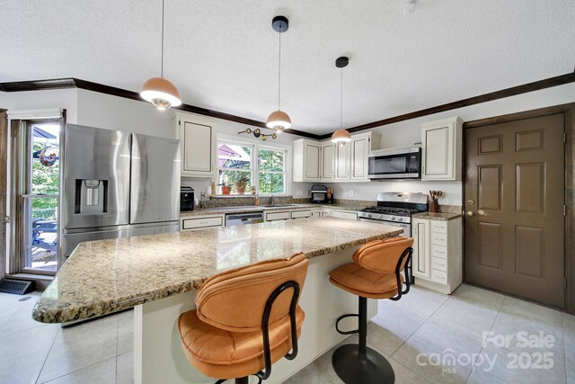 8524 Quarters Ln, Mint Hill, NC 28227 - kitchen with stainless steel appliances, a textured ceiling, ornamental molding, light tile patterned floors, and a breakfast bar