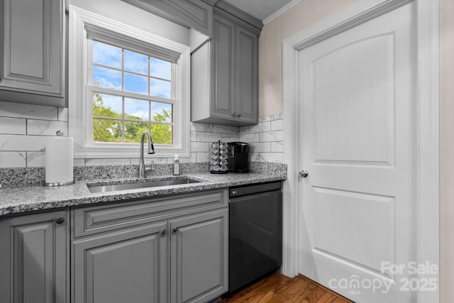 kitchen with crown molding, a sink, black dishwasher, and gray cabinetry