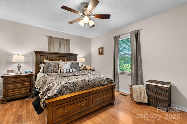 bedroom featuring baseboards, a ceiling fan, and light wood-type flooring