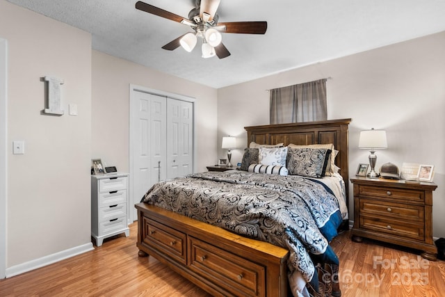 bedroom with light wood-style floors, baseboards, a ceiling fan, and a closet