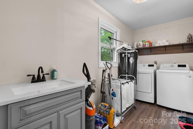 laundry room with a sink, dark wood-style flooring, cabinet space, and washing machine and clothes dryer