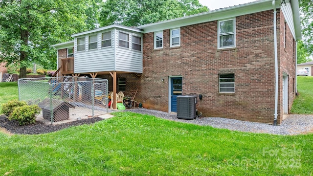 back of house featuring a lawn, central AC, and brick siding