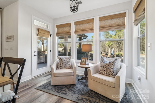 sunroom / solarium featuring baseboards and wood finished floors