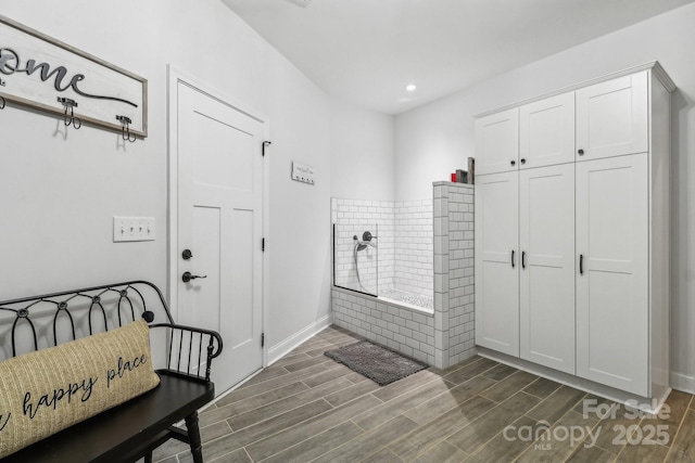 full bath featuring tiled bath, baseboards, recessed lighting, and wood finished floors