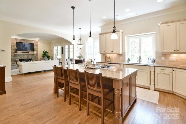 5827 Rileys Ridge Rd, Charlotte, NC 28226 - kitchen featuring arched walkways, tasteful backsplash, light stone countertops, light wood-type flooring, and a sink